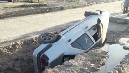 Uno de los autos que cayó al pozo.